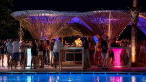a group of people standing around a pool at a party at BLACK AMBER BOUTIQUE HOTEL in Lampi +94 photos