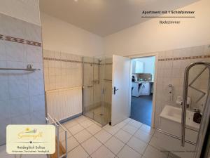 a bathroom with a shower and a toilet and a sink at Heideglück Soltau - Ferienwohnungen An der Weide in Soltau +29 photos