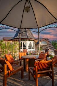 a patio with chairs and a table with an umbrella at Hazaar Dastaan Kashmir in Srinagar