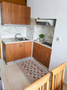 a small kitchen with wooden cabinets and a sink at House in the old town with view in Gjirokastër +30 photos