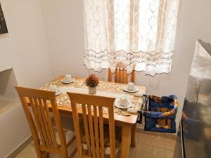 a dining room table with two chairs and a window at House in the old town with view in Gjirokastër