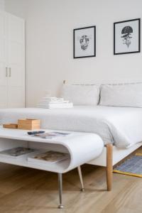a white bedroom with a bed and a coffee table at Canonica Suites in Bologna