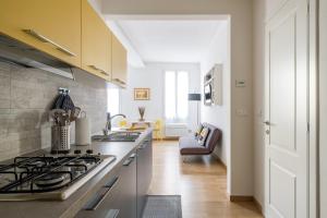 a kitchen with a stove top oven next to a living room at Canonica Suites in Bologna +51 photos