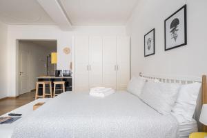 a white bedroom with a bed and a kitchen at Canonica Suites in Bologna