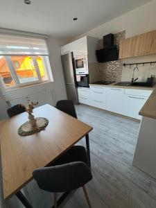 a kitchen with a wooden table and chairs and a kitchen with white cabinets at Apartmán Olive in Terchová +7 photos