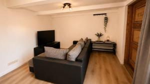 a living room with a black couch and a television at Ferienwohnung Hoffmann in Radebeul