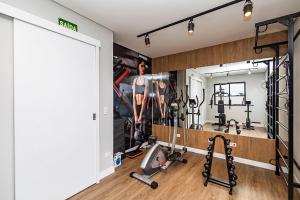 a gym with a mirror and some exercise equipment at Cabral Smart Comfort in Curitiba