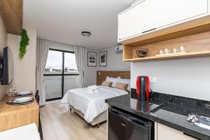 a small kitchen with a bed in a room at Cabral Smart Comfort in Curitiba
