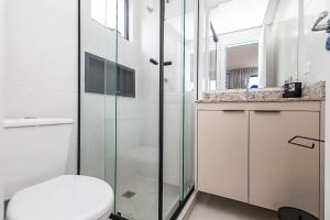 a bathroom with a toilet and a glass shower at Cabral Smart Comfort in Curitiba +52 photos