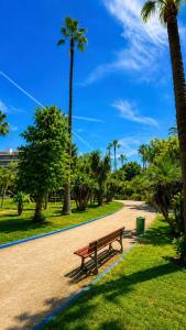 a park bench on a path with palm trees at Sea and Sand in Antibes
