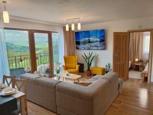 a living room with a couch and a table at Apartamenty Kaniówka 25 in Gliczarów Górny