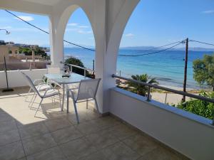 a balcony with a table and chairs and the ocean at Marinas house in Vaia