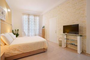 a bedroom with a bed and a flat screen tv at Montellino's Suite Oro in SantʼAntìoco