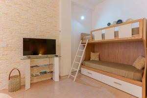 a small room with bunk beds and a tv at Montellino's Suite Oro in SantʼAntìoco