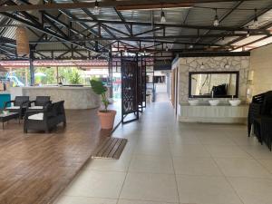 a lobby with a waiting area with chairs and tables at Hotel Oasis Beach Club in Puntarenas