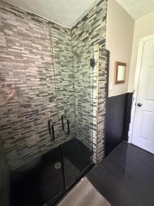 a bathroom with a glass shower with a brick wall at April Palace green in Decatur