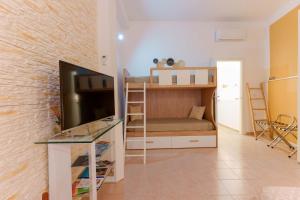 a living room with a bunk bed and a tv at Montellino's Suite Oro in SantʼAntìoco +60 photos