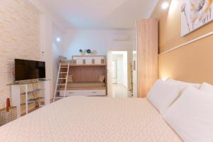 a bedroom with a large bed and a television at Montellino's Suite Oro in SantʼAntìoco
