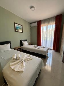 a hotel room with two beds and a window at Hotel Solaris in Čanj