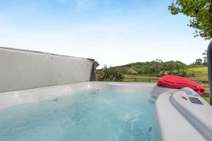 a hot tub with a red towel sitting in it at 1 Bed in Hereford oc-81293 in Aconbury
