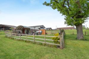 a fence with a tree and a trailer in a field at 1 Bed in Hereford oc-81293 in Aconbury