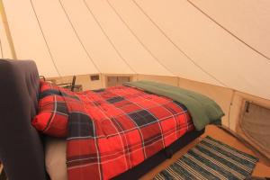 a red and black blanket is sitting in a tent at Stamsjö Glamp in Åsele