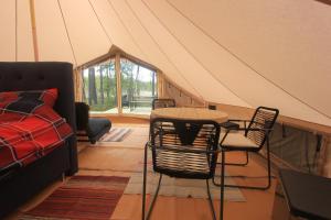 a room with a tent with a table and chairs at Stamsjö Glamp in Åsele