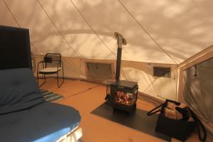 a room with a stove in a tent at Stamsjö Glamp in Åsele