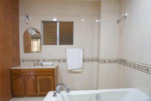 ein Badezimmer mit Badewanne, Waschbecken und Spiegel in der Unterkunft Hotel Real Alteño in Tepatitlán + 16 Fotos