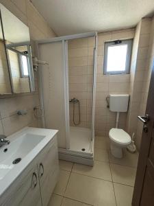 a bathroom with a shower and a toilet and a sink at Hotel Solaris in Čanj +19 photos