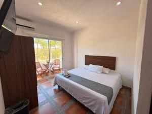a bedroom with a bed and a balcony with a table at Lofts Terra Nuevo Vallarta in Nuevo Vallarta +35 photos