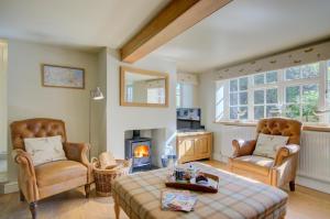 a living room with two chairs and a fireplace at 2 Bed in Blakeney oc-1977 in Blakeney