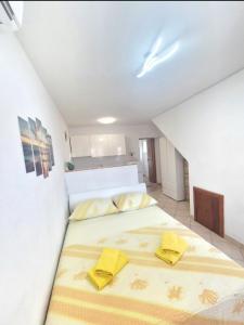 a bedroom with a large bed with yellow pillows on it at Apartments Mate in Komiža