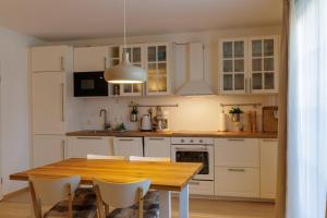 a kitchen with a wooden table and white cabinets at Ostseekoje Prerow in Prerow