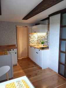a kitchen with white cabinets and a counter top at Craft Corner Apartment Namysłów - Rynek in Namysłów +13 photos