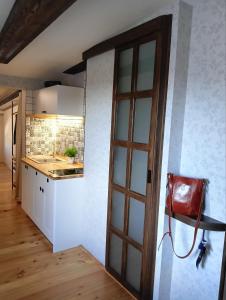 a kitchen with a door leading into a room at Craft Corner Apartment Namysłów - Rynek in Namysłów