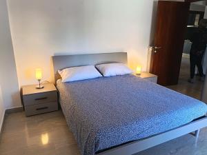 a bedroom with a bed with two lamps on tables at Home Marí in Sessa Aurunca