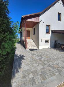 a white house with a patio and stairs at Józefinka House of Energylandia Zator in Spytkowice