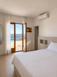 a bedroom with a bed and a view of the beach at Pansion Marjan in Zavala