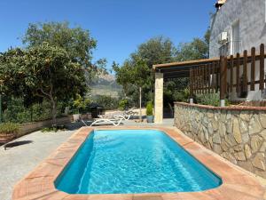 a swimming pool in front of a house at Villa Río Béjar in Quesada