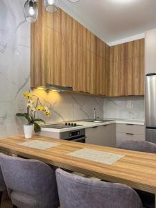 a kitchen with a wooden table with purple chairs at JoHa Stay in Bar