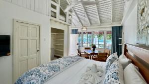 a bedroom with a bed and a dining room at Yellow Bird Sea in Negril
