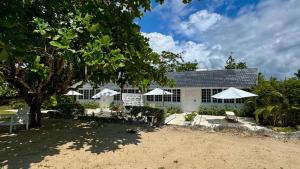 a house with chairs and umbrellas in front of it at Yellow Bird Sea in Negril