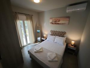 a bedroom with a bed with two white pillows at Μπαλκόνι με Θέα in Pérdika