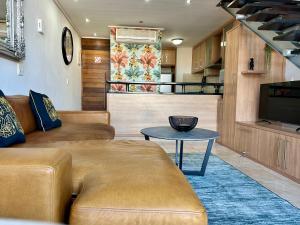 a living room with a couch and a table at Meerendahl Luxury Apartments at Tyger Lake in Cape Town
