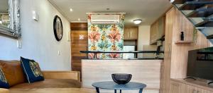 a living room with a couch and a table at Meerendahl Luxury Apartments at Tyger Lake in Cape Town
