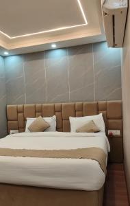 a bedroom with a large bed with white pillows at Blueberry Premium Hotel in Greater Noida