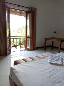 a bedroom with a bed and a sliding glass door at Ruwan's HomeStay in Matale +9 photos