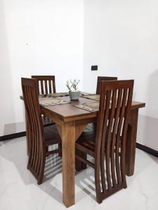 a wooden table with three wooden chairs around it at Ruwan's HomeStay in Matale