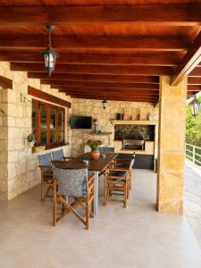 an outdoor patio with a table and chairs at Koutsini Villa in Pano Akourdalia